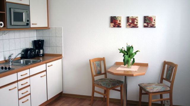 Helle Küche in einer Magdeburger Wohnung mit modernem Tisch und Stühlen, ideal zum Mieten für gemütliche Wohnatmosphäre.