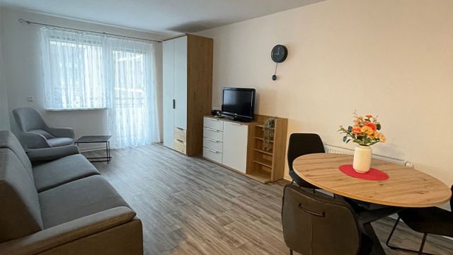 Helles Wohnzimmer in Magdeburg mit gemütlichem Sofa und Esstisch bietet eine einladende Atmosphäre für Mieter.